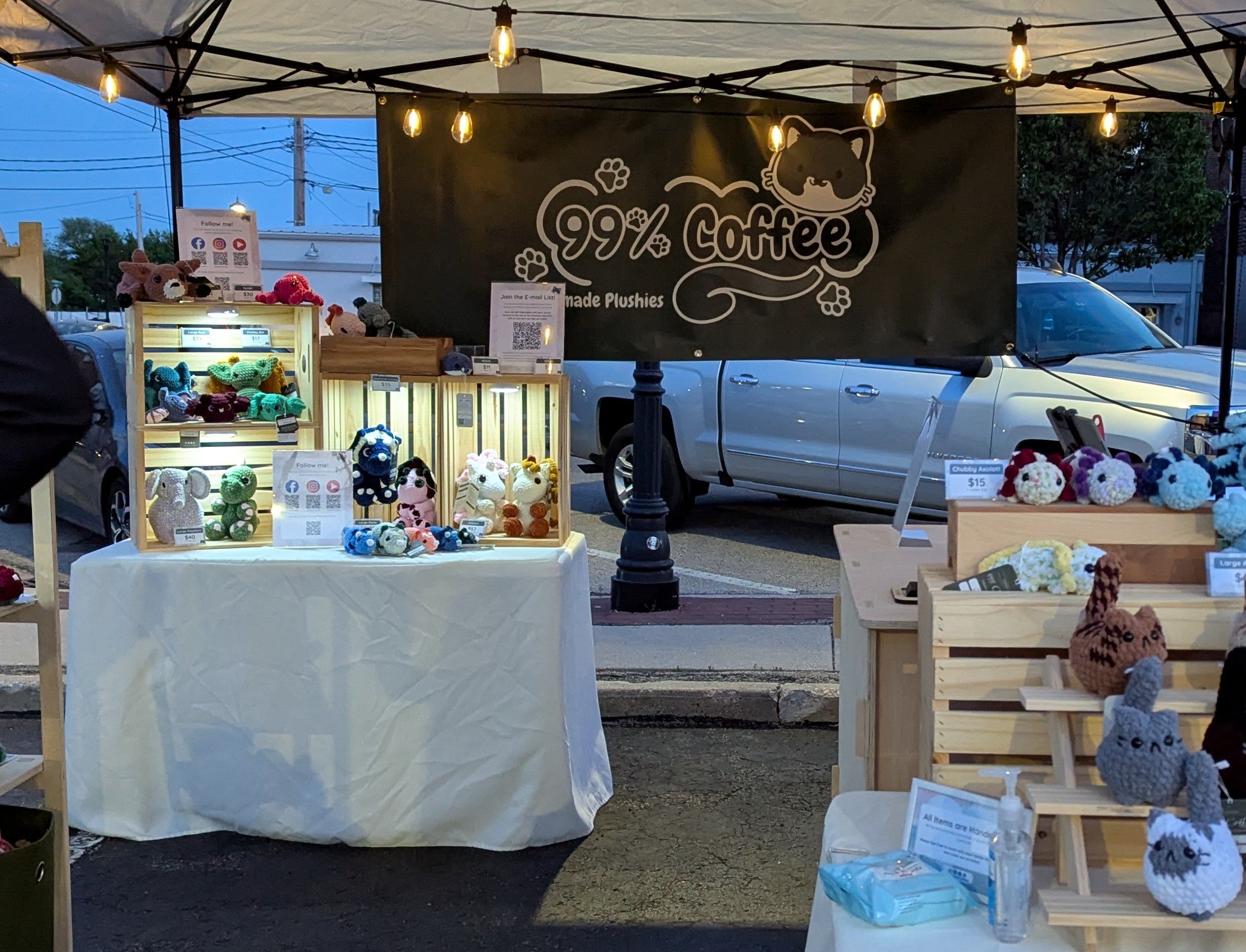 Stall with '99% Coffee' branding featuring plush toys and stuffed animals.